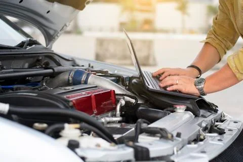 Technical man is using laptop to tuning racing car with engine bay view. Stock Photos