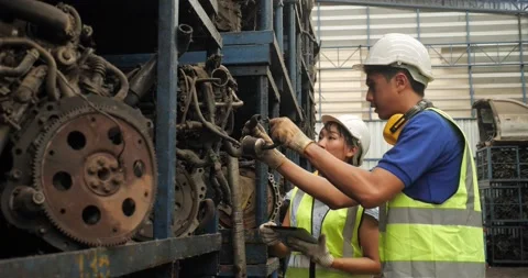Technical with safety suit helmet checking stock of used auto parts  Stock-Footage 173386454