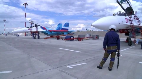 Technical serviceman waiting the fighter SU-27 for take-off at a military Stock Footage 73486051