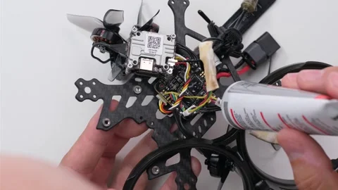 Technical Specialist apply silicone polish to connector of drone fpv Stock Footage 244334952