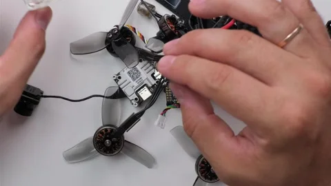 Technical Specialist take apart fpv drone to apply silicone to waterproof Stock Footage 244333302