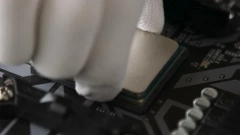 A technical specialist's hand in white gloves installs the CPU in socket Stock Footage 195154532