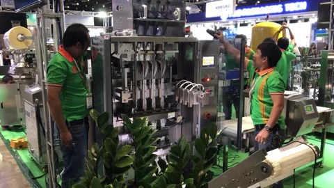 Technical staff are setting up modern industrial machinery for packaging Stock Footage 263411262