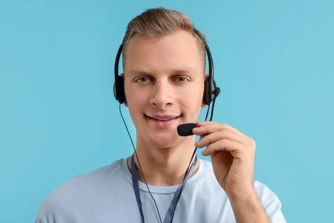 Technical support call center. Portrait of smiling operator on light blue b.. Stock Photos