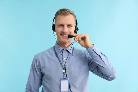 Technical support call center. Portrait of smiling operator on light blue b.. Stock Photos