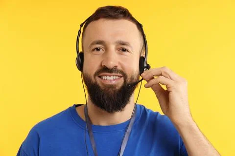 Technical support call center. Portrait of smiling operator on yellow backg.. Stock Photos