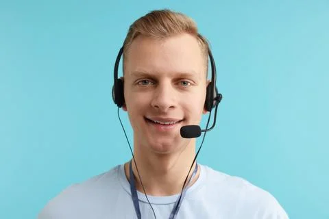 Technical support call center. Portrait of smiling operator on light blue b.. Stock Photos