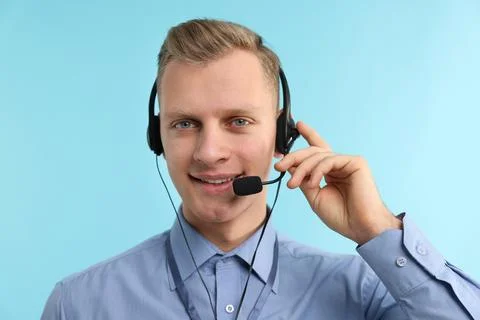 Technical support call center. Portrait of smiling operator on light blue b.. Stock Photos