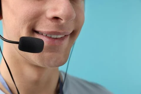 Technical support call center. Smiling operator on light blue background, c.. Stock Photos