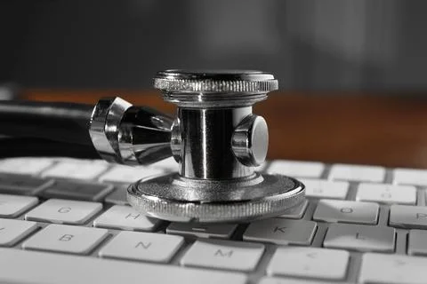 Technical support concept. Stethoscope and keyboard on wooden table, closeup Stock-Fotos