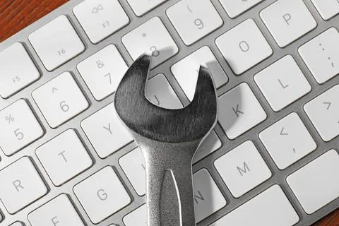Technical support concept. Wrench and keyboard on wooden background, top view Stock-Fotos