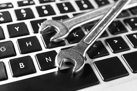 Technical support concept. Wrenches on laptop keyboard, closeup Stock-Fotos