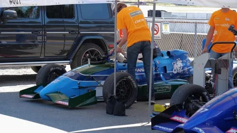 Technical support guys assisting Formula One driver before racing. Видео 157802378