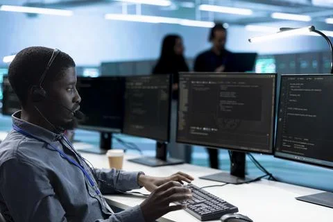 Technical support, headset and technician at data center workstation Stock Photos
