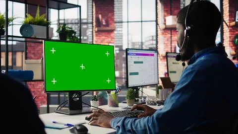 Technical support specialist in call center office using green screen PC Stock Photos