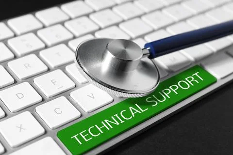 Technical support. Stethoscope and keyboard with green button on black tabl.. Stock-Fotos