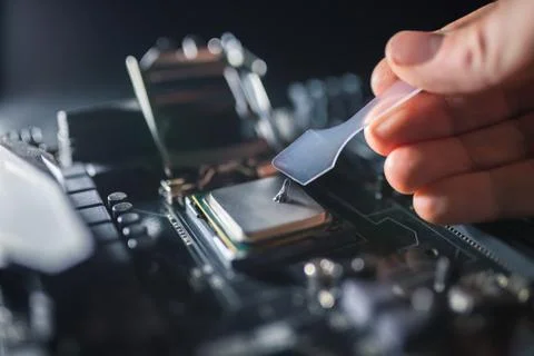 Technical support worker greases with thermal grease paste computer processor 写真素材
