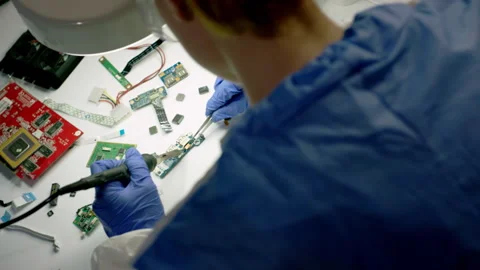 Technical worker solders motherboard of electronic device Stock Footage 246472147