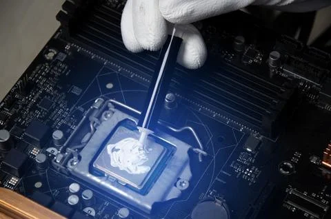 The technician is adding thermal silicone to the CPU chip. Stock Photos