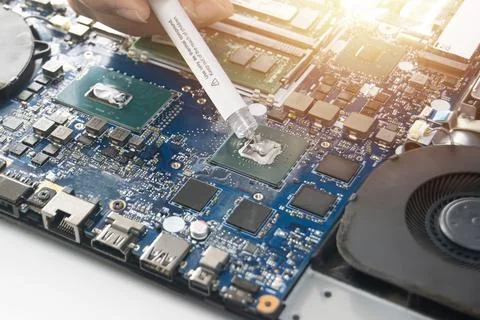 Technician is adding thermal silicone to the CPU. Stock Photos