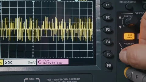 Technician Adjusting Electrical Signal on Digital Oscilloscope Screen Stock Footage 329963271