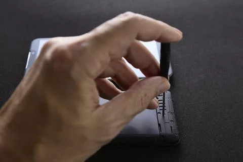 Technician adjusting internal smartphone components during repair Stock Photos