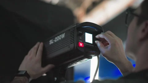 Technician adjusting led studio light power switch and brightness on sl200w Stock Footage 317588792