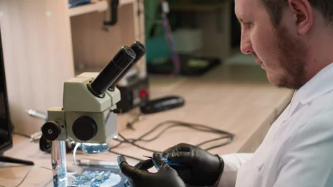 Technician Adjusting Screw with Electronic Component Under Microscope Stock Footage 281372573