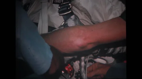 Technician adjusting straps as astronaut sitting on spacecraft couch Stock Footage