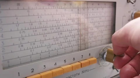 Technician Adjusting Tuning Knob on Vintage Analog Frequency Signal Generator Stockbeeldmateriaal 334116339