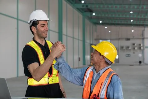 Technician and engineer discussing working together in warehouse. Foto stock