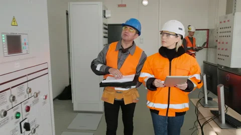 Technician and engineer with tablet and papers at substation Stock Footage 143957657
