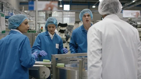 Technician and workers discussing while working on production line in factory Stock Footage 107961758