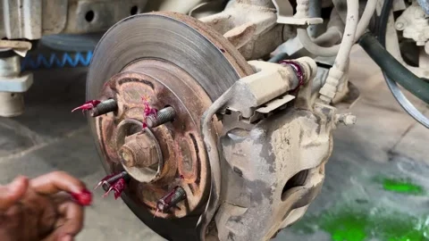 Technician applying lubricant to disk brake hardware during passenger vehic.. Stock Footage 339476848