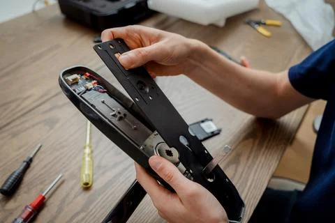 A technician assembles and installs smart electronic door lock for house Stock Photos
