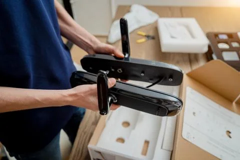 A technician assembles and installs smart electronic door lock for house Stock Photos