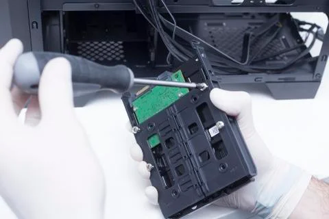 Technician assembling computer hardware parts. Hard drive being installed in  Stock Photos