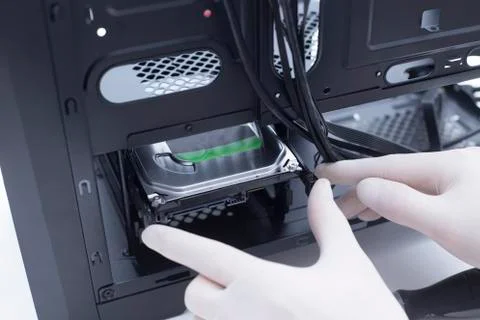 Technician assembling computer hardware parts. Hard drive being installed in  Stock Photos