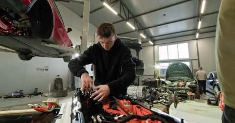 Technician Assembling Electric Vehicle Battery in Modern Workshop 動画素材 277303060