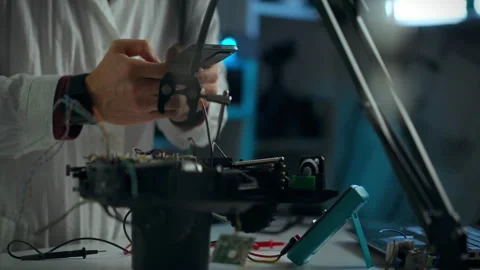 A technician assembling electronic components in a workshop during evening h Stock Footage 289576600