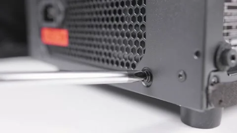 Technician assembly computer using screwdriver to instal screws of power supply Stock Footage 234223833