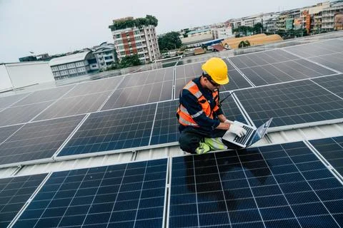 Technician assesses solar panel performance on rooftop in urban setting dur.. Stock Photos