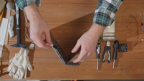 Technician brushes USB inputs and examines laptop Stock Footage 129972243
