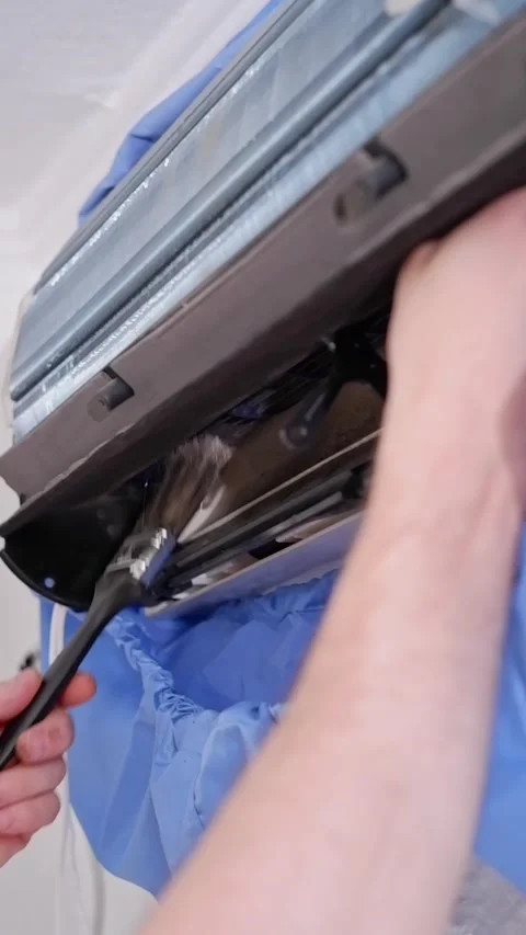 Technician brushing dust from air conditioner unit Stock Footage 338008629