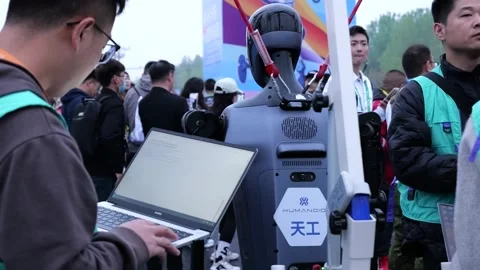 Technician calibrates humanoid robot ahead of a unique half-marathon in Stock Footage 309113159