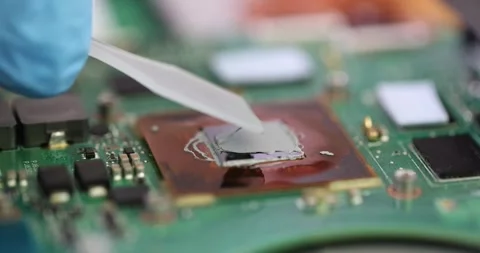 Technician carefully applies thermal paste to computer processor Stock Footage 308881793