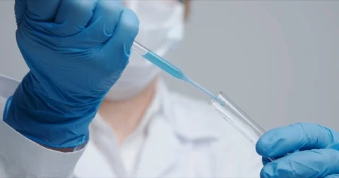 Technician carefully drips the solution from the pipette into glass tubes. Stock Footage 125898442