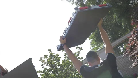 A technician carries a rectangular segment of an LED panel 動画素材 143035235