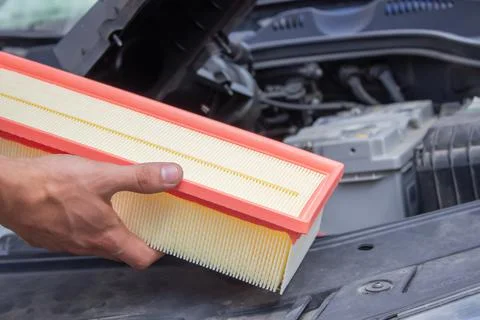 Technician changes car filter, car spare part. Car service concept. Stock Photos