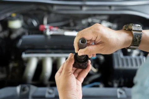 Technician check old spark plug coil with Burn marks on engine coil in Main.. Foto stock